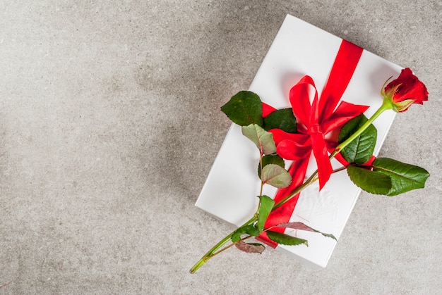 Holiday  background, Valentine's day. Wrapped gift box with one red rose top view