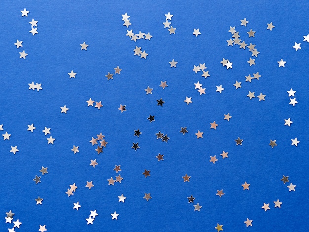 Holiday background with silver star confetti 