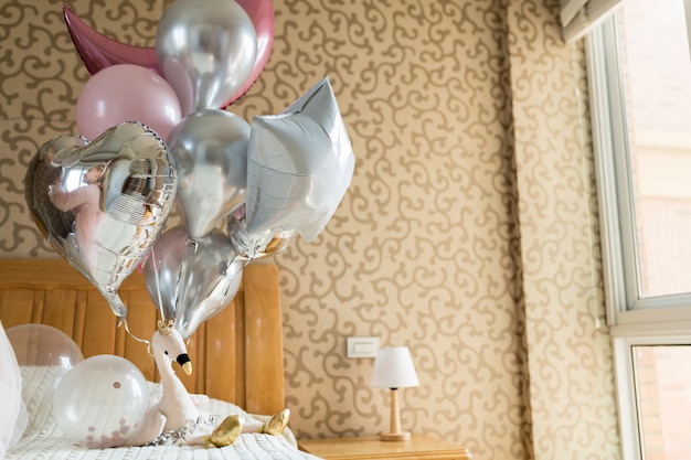 Holiday balloons and flamingo toy on the bed