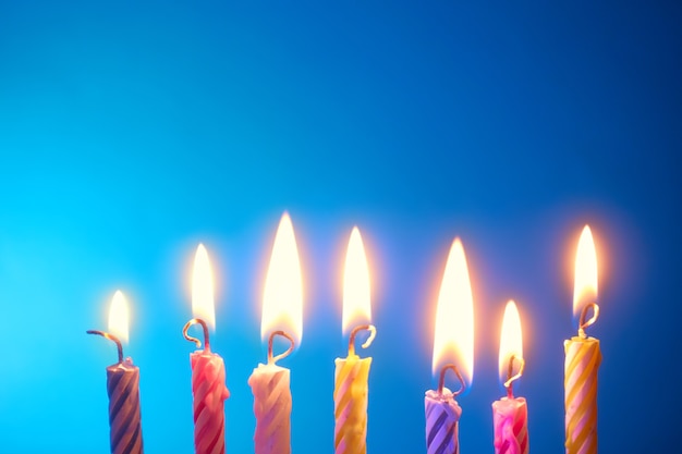 Holiday - birthday candles in a row over blue background