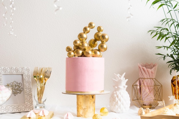 Tavolo di compleanno per le vacanze con torta e palloncini decorazione rosa e dorata