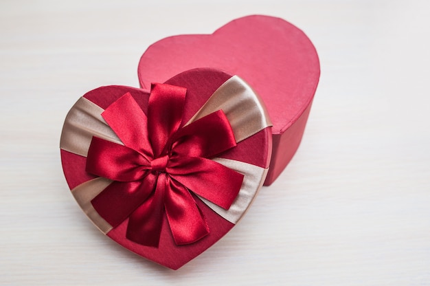 The holiday box in the shape of a heart with a bow on Valentine's Day