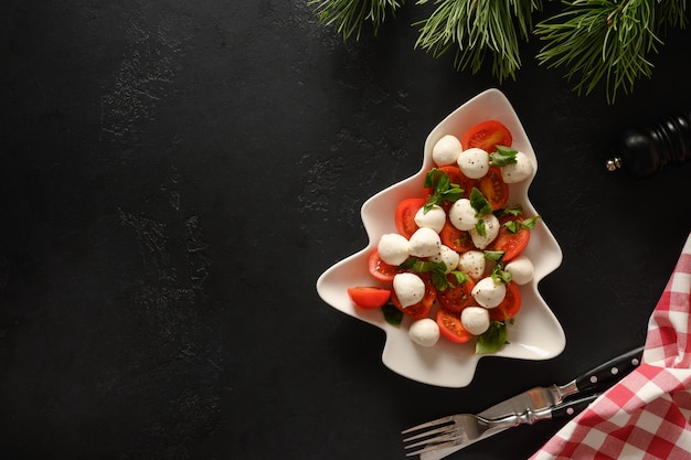 Holiday Caprese salad in plate shape of Christmas tree for festive Xmas party