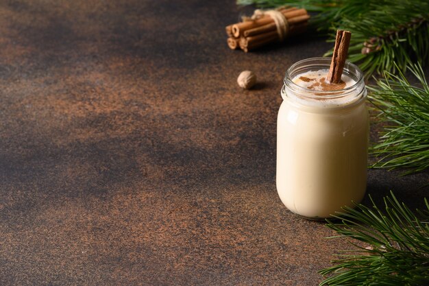 Holiday christmas advocaat met kaneel op bruine achtergrond. detailopname. kopieer ruimte.