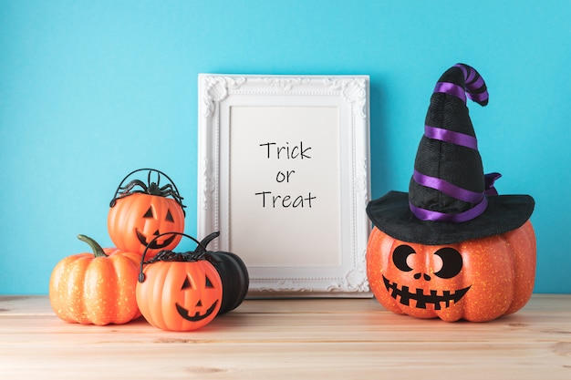 Holiday concept with funny Halloween pumpkin decor and photo frame on wooden table