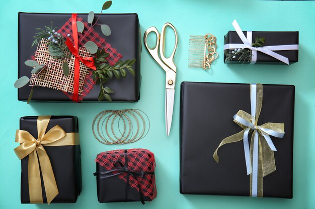 Фото Концепция праздничного декора. стильные подарочные коробки и аксессуары на синем фоне