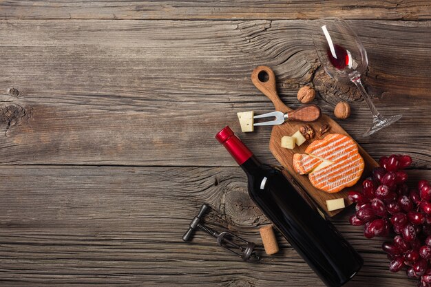 Holiday Dinner setting with red wine and creaming cheese on rustic wood. Top view with space for your greetings.