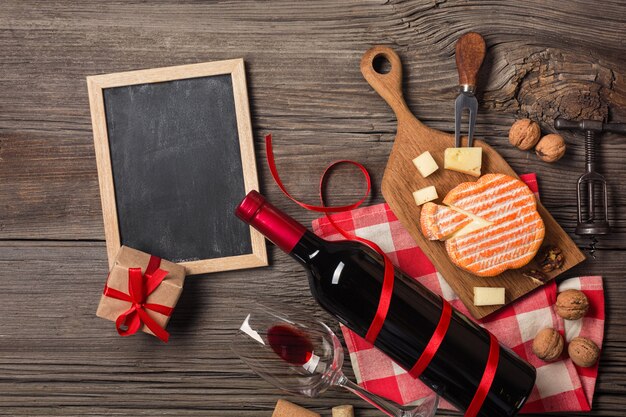 Holiday Dinner setting with red wine and creaming cheese on rustic wood. Top view with space for your greetings.