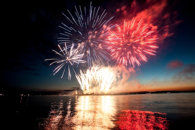 Holiday fireworks above water with reflection on the black sky background ok