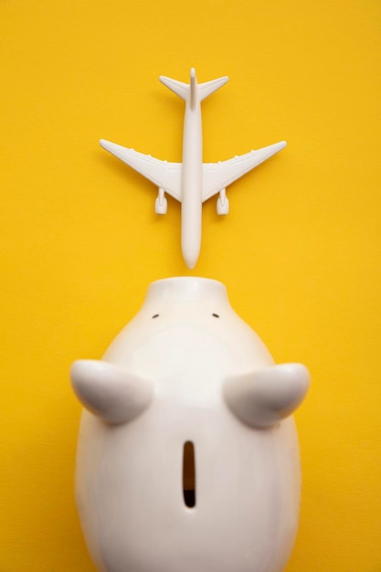 Holiday flight fare saving concept. piggy bank with a toy plane. vacation budget planning