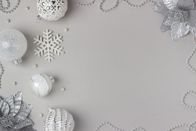 Photo holiday frame made silver and white shiny christmas decorations on grey background. happy christmas, xmas and new year concept. top view, flat lay, copy space