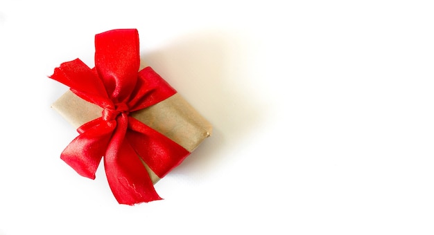 Holiday gift box with red ribbons on a white background.