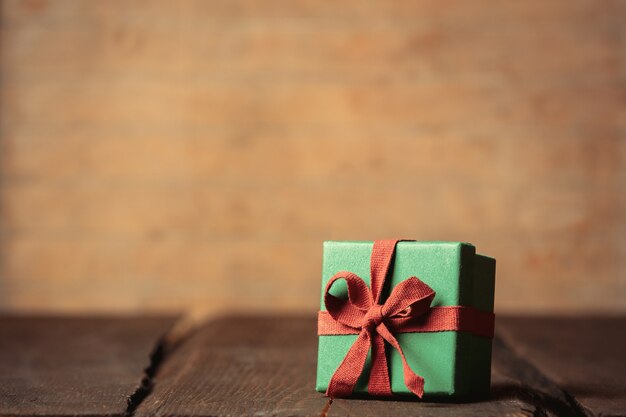 Holiday gift box on wooden table. Image in vintage color style