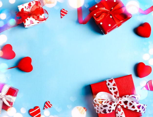 Holiday gifts. Red gift boxes on blue background. Valentines day concept. Top view, copy space