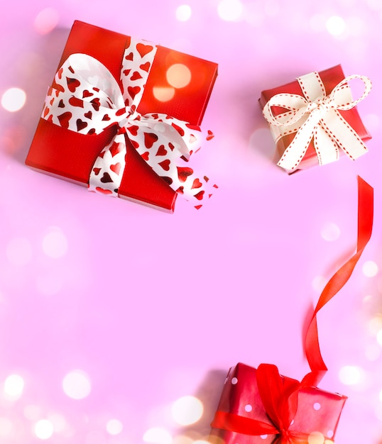 Holiday gifts. Red gift boxes on pink . Valentines day . Christmas gift.