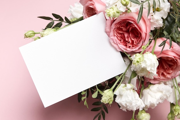 Holiday greeting card mockup with bouquet of flowers on light pink background