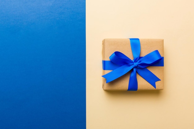 Праздничный бумажный подарок ручной работы связанный голубой лентой бант вид сверху с копией пространства Плоский лежал праздничный фон День рождения или рождественский подарок Концепция рождественской подарочной коробки с копией пространства