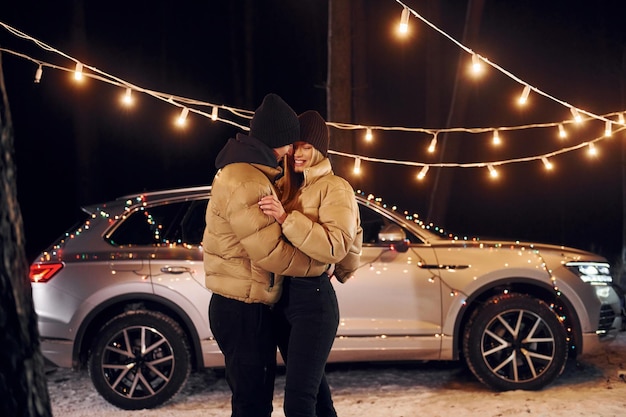 Holiday mood and decorations Couple standing in the forest and celebrating New year