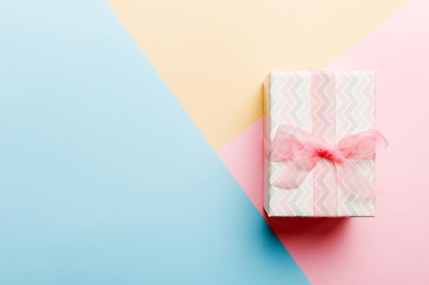 Праздничный бумажный подарок, связанный розовой лентой, бант, вид сверху с копией пространства Плоский лежал праздничный фон День рождения или рождественский подарок Концепция рождественской подарочной коробки