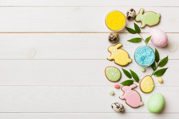 Подготовка к празднику Разноцветные пасхальные яйца с печеньем на цветном фоне Пастельные цветные пасхальные яйца концепция праздника с копией пространства