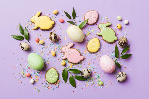 Holiday preparation Multi colors Easter eggs with cookies on colored background Pastel color Easter eggs holiday concept with copy space