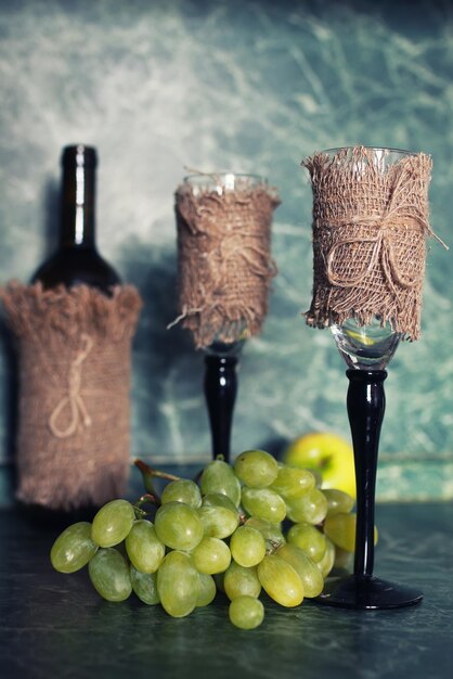 Holiday set wine bottle with green grape on background