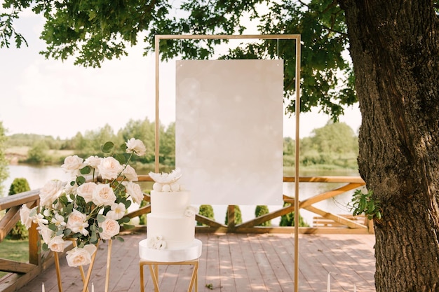 Decorazioni per feste o matrimoni con bellissime composizioni di rose bianche con uno sfondo vuoto e una torta bianca in natura