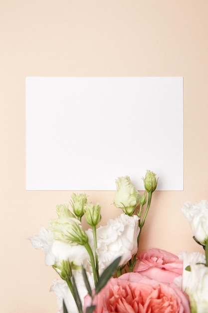 Holiday wenskaart mockup met bloemen op lichte beige achtergrond bovenaanzicht plat leggen