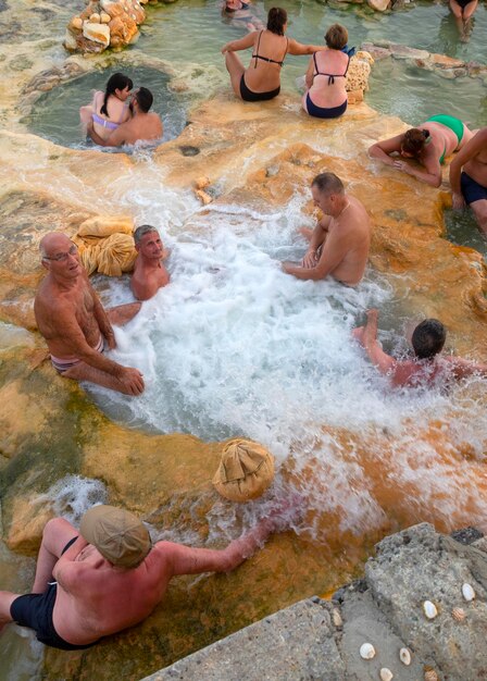 Foto i turisti fanno bagni curativi naturali presso le sorgenti termali della località termale loutra edipsou in grecia