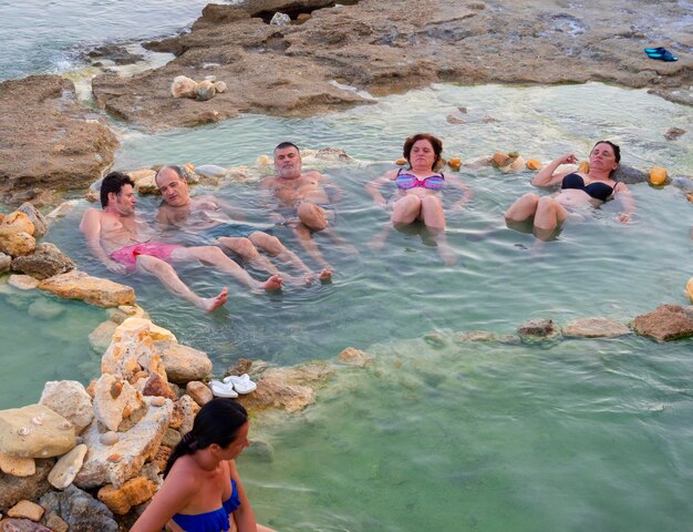 行楽客はギリシャのスパリゾートLoutraEdipsouで温泉で自然治癒浴をします