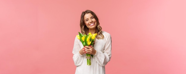 Holidays beauty and spring concept portrait of lovely caucasian blond girl in white dress smiling up