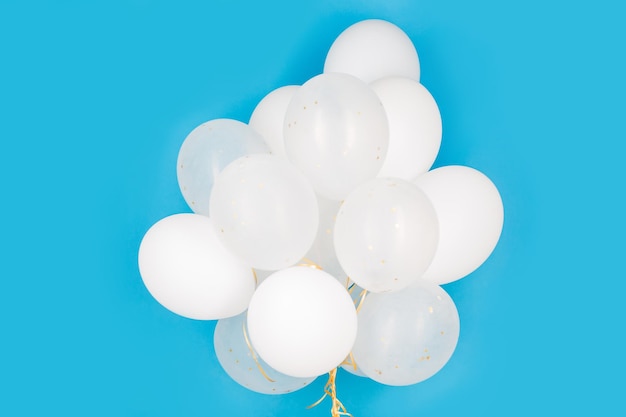 holidays, birthday, party and decoration concept - close up of inflated white helium balloons over blue background