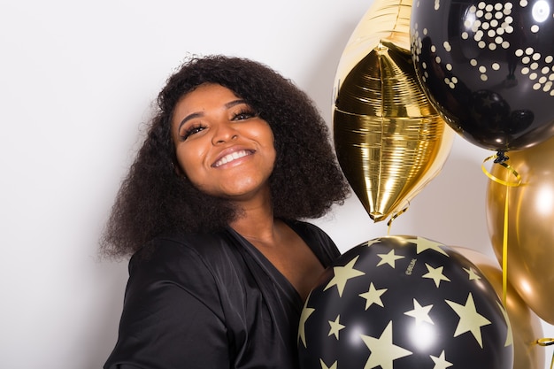 Vacanze, festa di compleanno e concetto di divertimento - ritratto di giovane donna giovane afro-americana sorridente