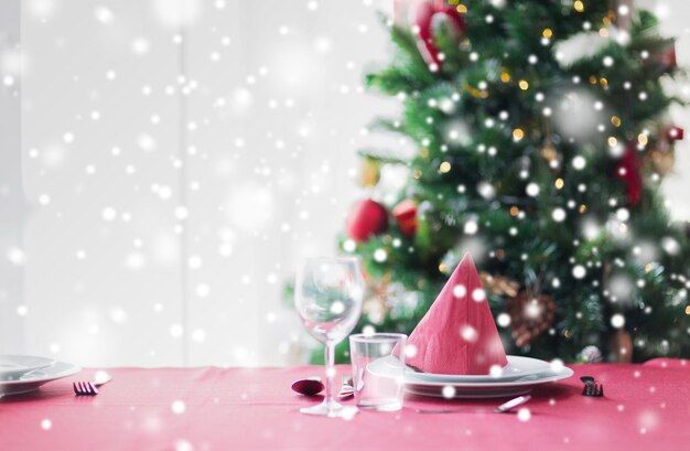 holidays, celebration and home concept - close up of room with christmas tree and decorated table