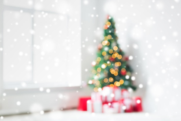 holidays, celebration and home concept - living room with christmas tree and presents background