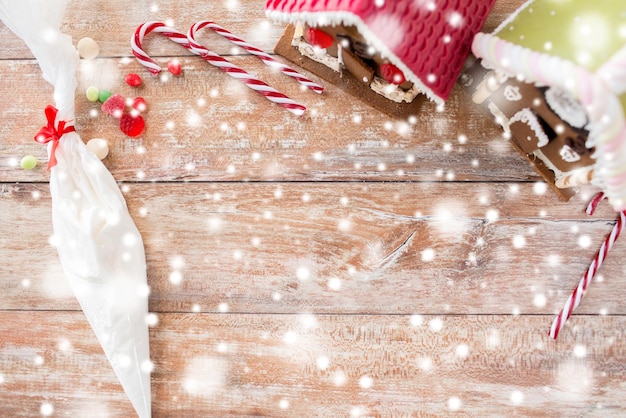 концепция праздников, рождества, выпечки и сладостей - крупный план красивых пряничных домиков и глазурь на чистом столе дома