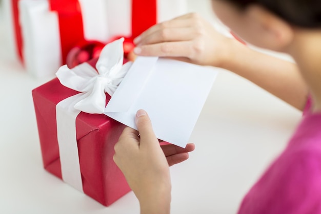 holidays, communication and people concept - close up of woman with letter and presents