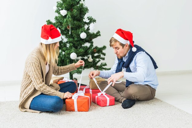 Holidays, family and festive concept - Couple with Christmas gifts at home.