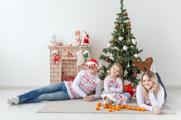 Holidays and festive concept - Happy family portrait by Christmas tree.