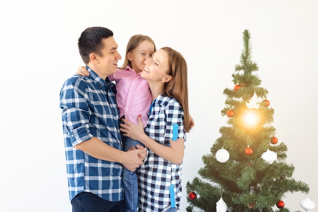 Holidays, gifts and christmas tree concept - Small family having happy time together on Christmas.