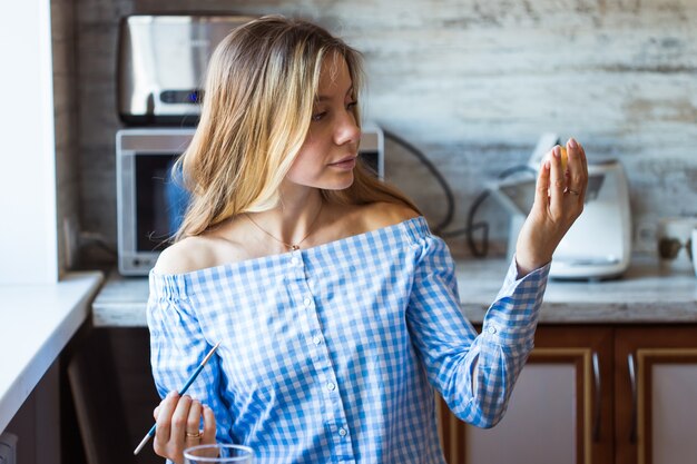 Foto vacanze, concetto di creazione e fatto a mano: la giovane donna felice attinge all'uovo di pasqua.