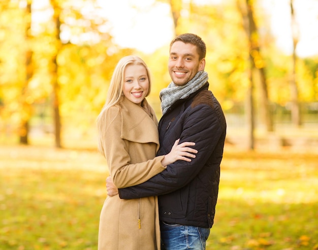 holidays, love, travel, tourism, relationship and dating concept - romantic couple in the autumn park