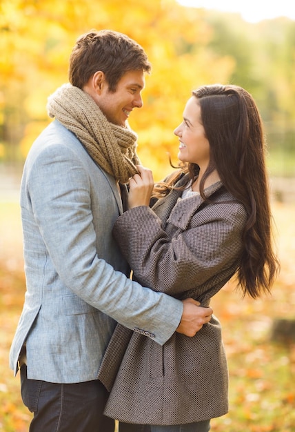 holidays, love, travel, tourism, relationship and dating concept - romantic couple in the autumn park