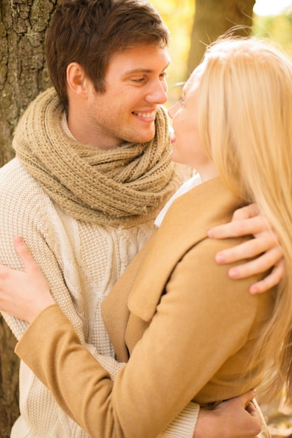 휴일, 사랑, 여행, 관광, 관계 및 데이트 개념 - 가을 공원에서 키스하는 로맨틱 커플