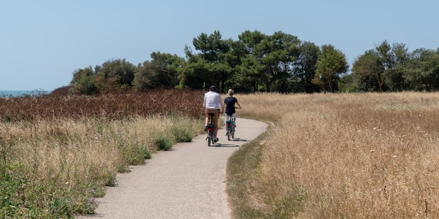 Holidays maker riding bike in Island Aix France in web banner template