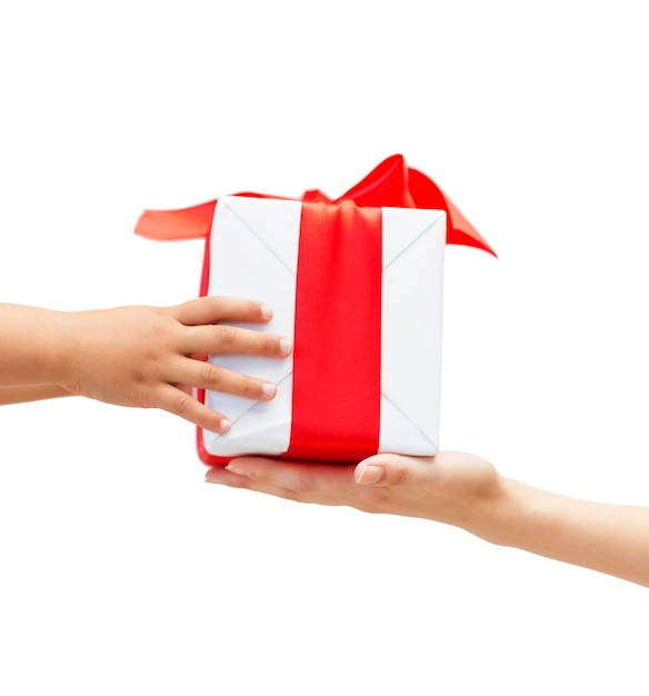 Vacanze, presente, natale, infanzia e concetto di felicità - primo piano delle mani del bambino e della madre con confezione regalo