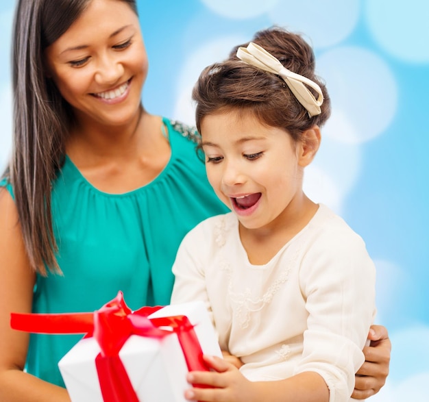 Vacanze, regali, natale, natale, concetto di compleanno - felice madre e bambina con confezione regalo