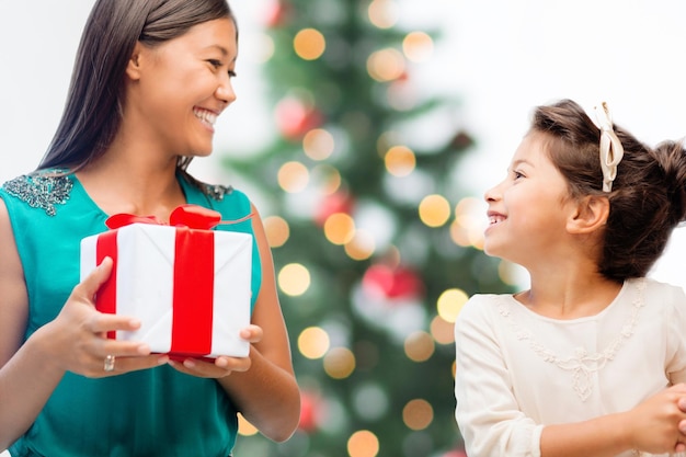 праздники, подарки, рождество, рождественская концепция - счастливая мама и дитя с подарочной коробкой