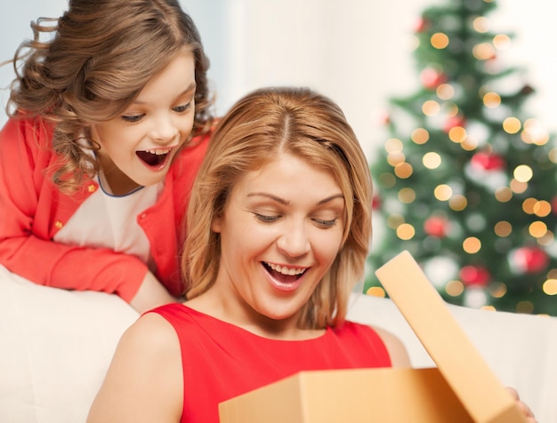 праздники, подарки, рождество, рождественская концепция - счастливая мать и дитя девочка с подарочной коробкой