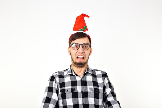 Holidays and presents concept - Funny emotional man in Christmas hat on white background with copyspace